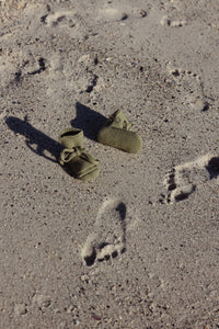 Hvid Booties Artichoke — groene babyslofjes op het strand