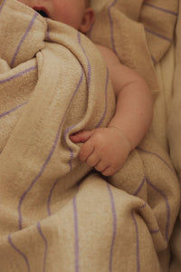 Hvid Harry Cream + Lilac — detail van babyhandjes en gestreepte deken