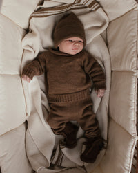 Hvid Georgette Mocha — baby in een draagmand met bruine wollen trui