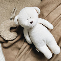 Moonie The Humming Bear 2.0 polyester cream op een deken naast een knuffeldoekje
